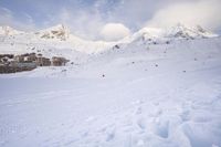 a skier makes his way up to the ski lodge in front of the mountain peaks