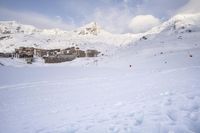 a skier makes his way up to the ski lodge in front of the mountain peaks