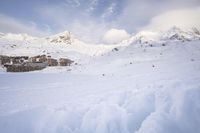 a skier makes his way up to the ski lodge in front of the mountain peaks