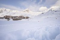 a skier makes his way up to the ski lodge in front of the mountain peaks