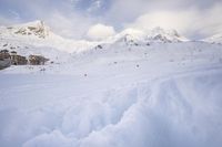 a skier makes his way up to the ski lodge in front of the mountain peaks