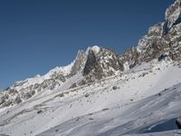 a person on skis walks along a snow covered mountain range with many snow covered mountains