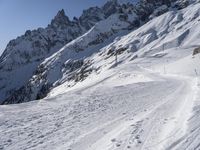 a lone skier making his way through a steep slope on snow covered skis in the alps