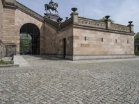 the outside entrance to the building with the statue of a man on a horse is near a wall