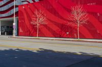 an american flag is painted on the side of a building near a street with cars