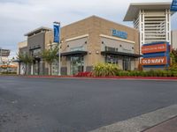 an american health university hospital is shown here, with several small signage, and a parking lot