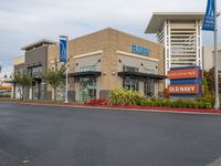 an american health university hospital is shown here, with several small signage, and a parking lot