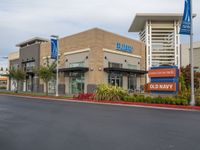 an american health university hospital is shown here, with several small signage, and a parking lot