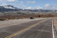 a car that is sitting in the road with mountains behind it for view of another vehicle