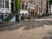 a paved street with parked cars near brick buildings and stairs down the middle of it