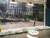 the view of bikes in a restaurant from a window with blue and white floral seating