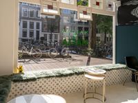 the view of bikes in a restaurant from a window with blue and white floral seating