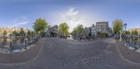 fisheye photo of an old canal cityscape with parked bicycles in the foreground