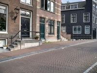 a brick road with two black doors on the one side of it and brick steps along both sides