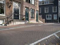 a brick road with two black doors on the one side of it and brick steps along both sides