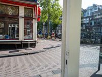 a view from an entrance at a street corner in amsterdam, showing a few bicycles and buildings in the background