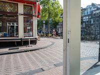 a view from an entrance at a street corner in amsterdam, showing a few bicycles and buildings in the background