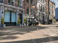 a brick street with two bicycles parked on either side of it and a tall building in the distance