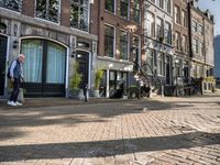 a brick street with two bicycles parked on either side of it and a tall building in the distance