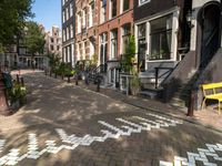 a bicycle lane and street lined with houses in the area where you can sit and watch people cross the road