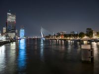 the river is empty at night near the city's buildings and street lights are reflecting on the water