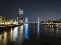 the river is empty at night near the city's buildings and street lights are reflecting on the water