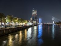 the river is empty at night near the city's buildings and street lights are reflecting on the water