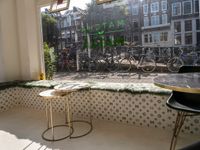 bikes are parked next to the window of a cafe with a view of the city