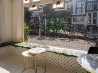 bikes are parked next to the window of a cafe with a view of the city