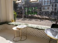 bikes are parked next to the window of a cafe with a view of the city