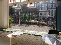 bikes are parked next to the window of a cafe with a view of the city