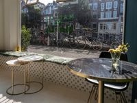 bikes are parked next to the window of a cafe with a view of the city