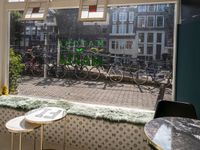 bikes are parked next to the window of a cafe with a view of the city