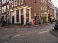 an image of buildings at the end of the street with bikes in front of it