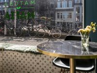 the restaurant is open to the public in holland, and features bikes parked near a window