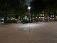 a street corner with bikes parked on the curb in front of them at night time