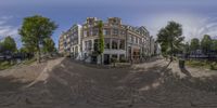 a panoramic image of a city street with buildings and trees by the water