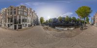 a fisheye shot of the street in front of some buildings and a water way