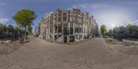 this circular photo shows a city street with houses and boats on it and people standing on the sidewalk in the center