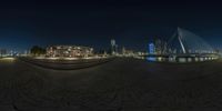 an image of a big city at night, taken in fish eye view of the walkway with people walking across it