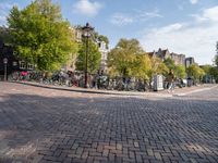 bicycles parked at a cobblestone road in a city street with many buildings behind them