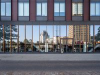 a view of some buildings in the background, as if from outside a glassy building