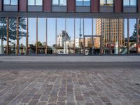 a view of some buildings in the background, as if from outside a glassy building