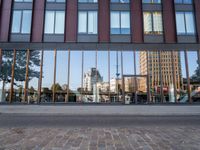 a view of some buildings in the background, as if from outside a glassy building