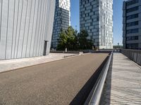 two buildings on either side of a walkway, with a bench in the middle of one