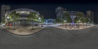 a panorama photo taken at night with no one visible in the street and an empty road