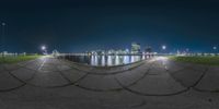 the city skyline is reflected in the lake and the lights are on behind it in this image