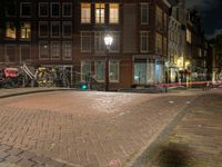 a street with a light that is shining on the street and people on a bench