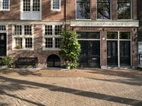 the girl is riding her bicycle in front of the building with the large windows of the old town house