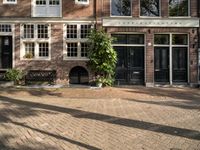 the girl is riding her bicycle in front of the building with the large windows of the old town house